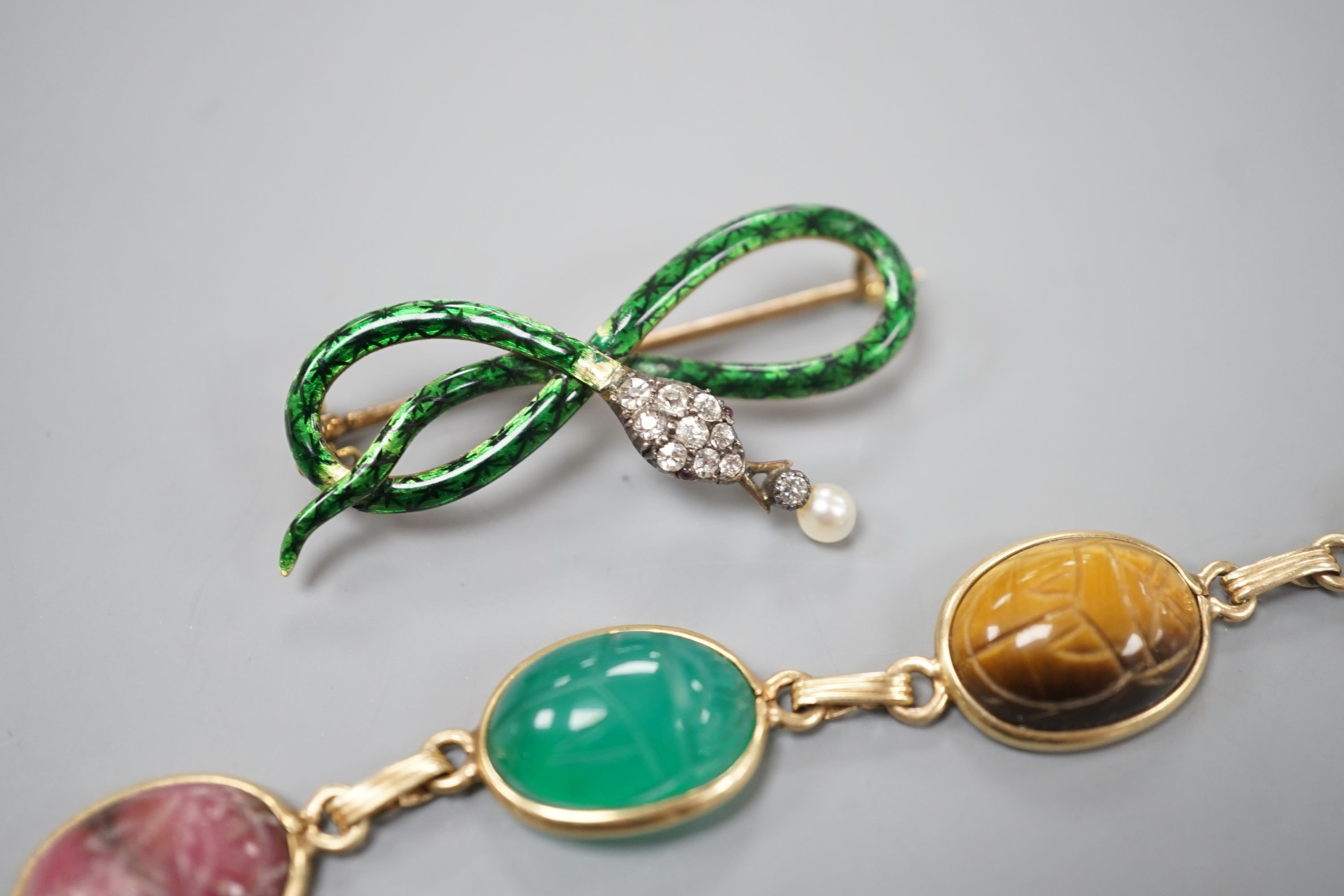 A 14k yellow metal and six stone multi gem set 'scarab' bracelet, 18.5cm, gross 15.4 grams and a yellow metal, diamond, drop pearl and green enamel set serpent brooch, gross 7.5 grams.